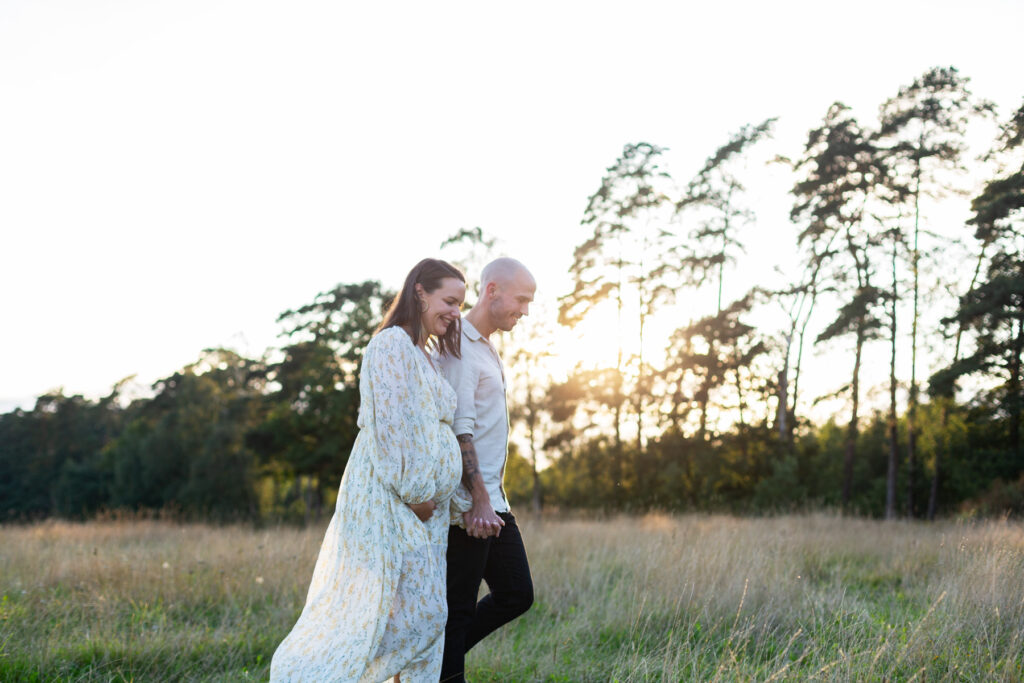 Ett par med gravidmage som kommer gående